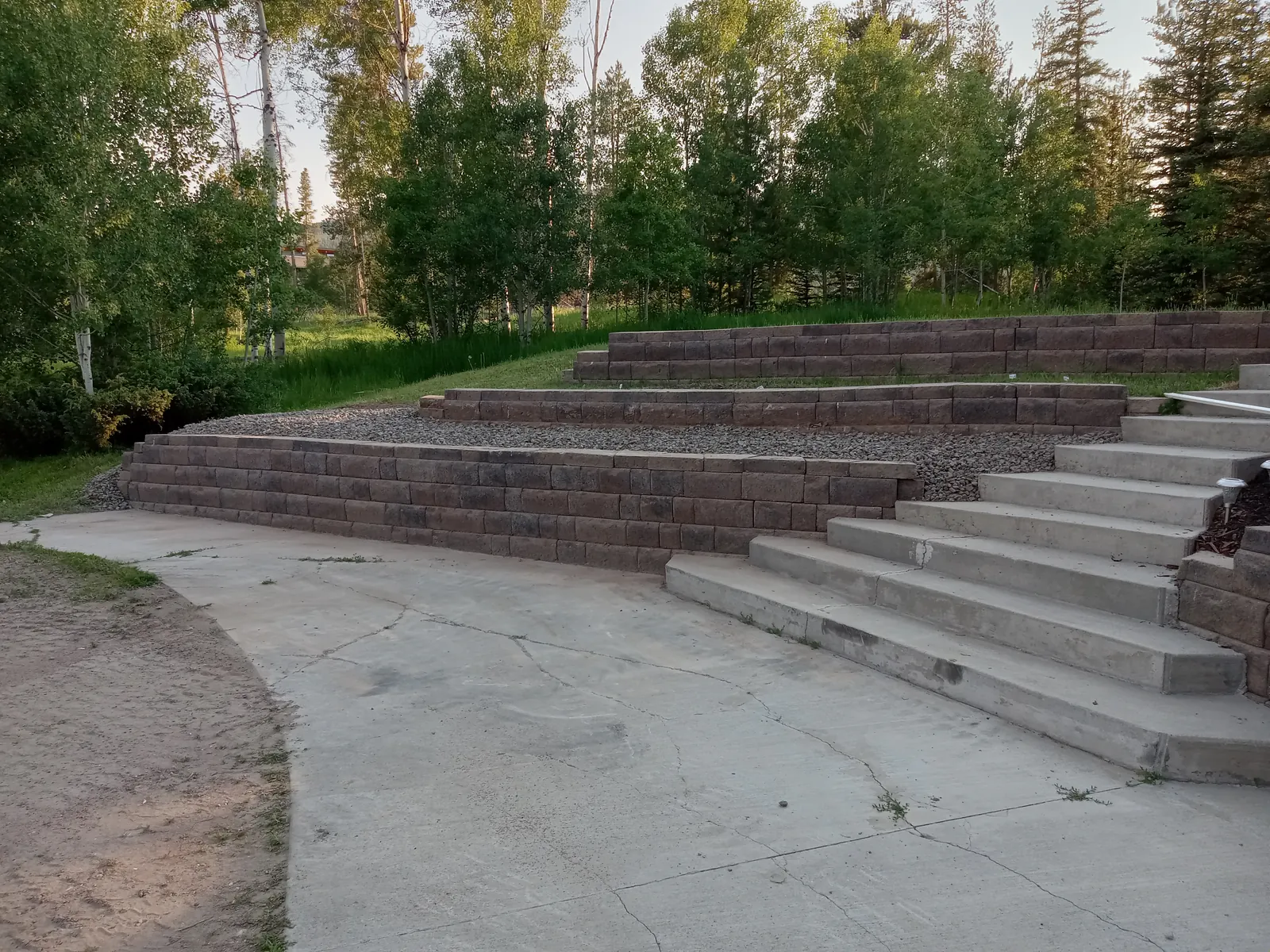 Tiered block retaining walls with concrete steps