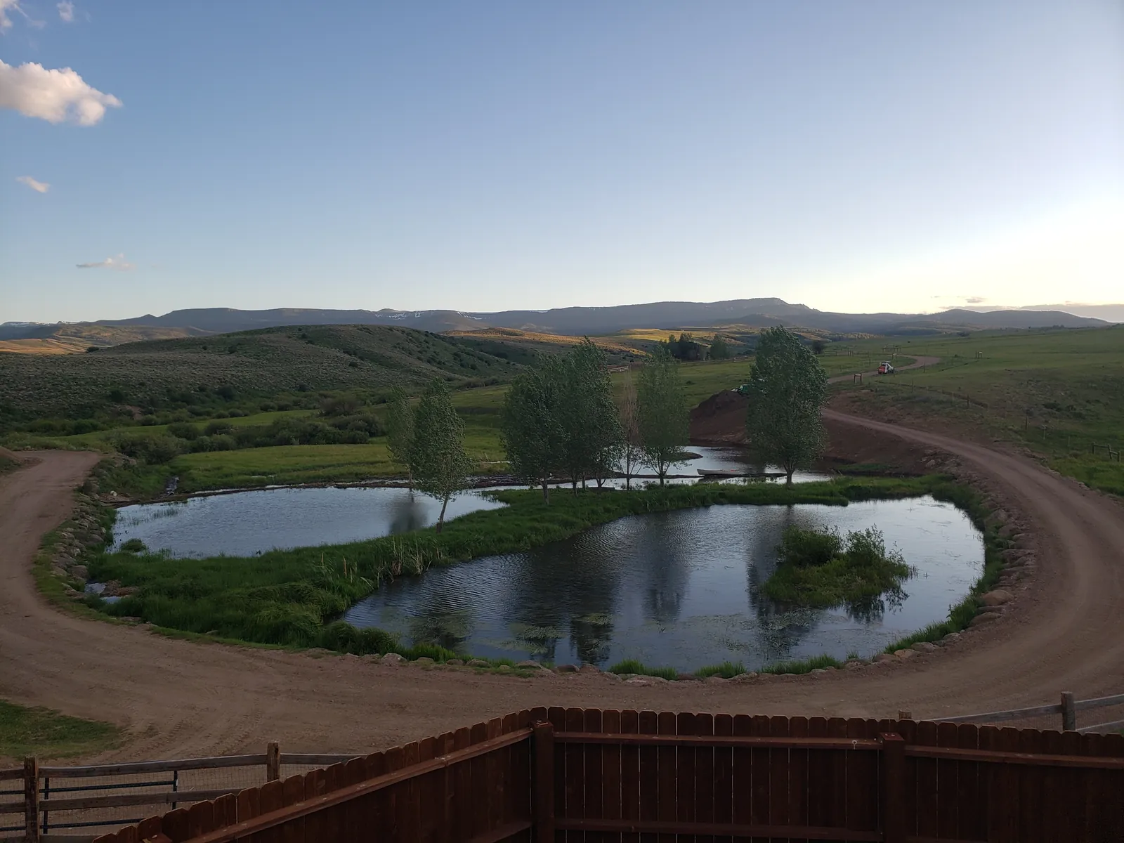 A pond with an island at evening, the Flat Tops on the horizon